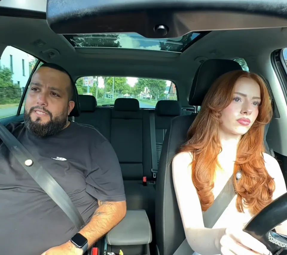 Tolga erklärt einer Fahrschülerin am Steuer das Tempo-30-Schild